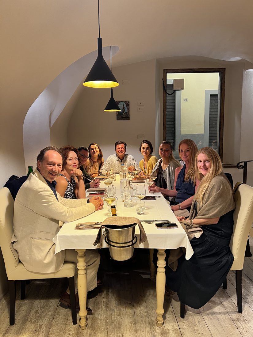 The whole group around a long table at the closing celebration dinner