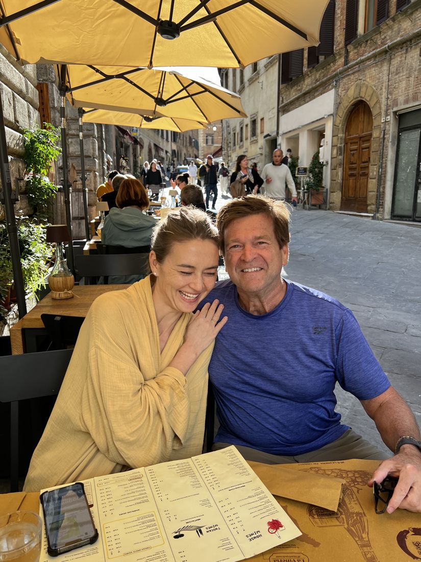 Two of the group at a cafe table on a street in Montepulciano